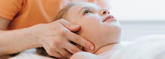 doctor osteopath hands does physiological and emotional therapy for eight year old kid girl. pediatric osteopathy treatment session. alternative medicine. taking care of the child's health. banner